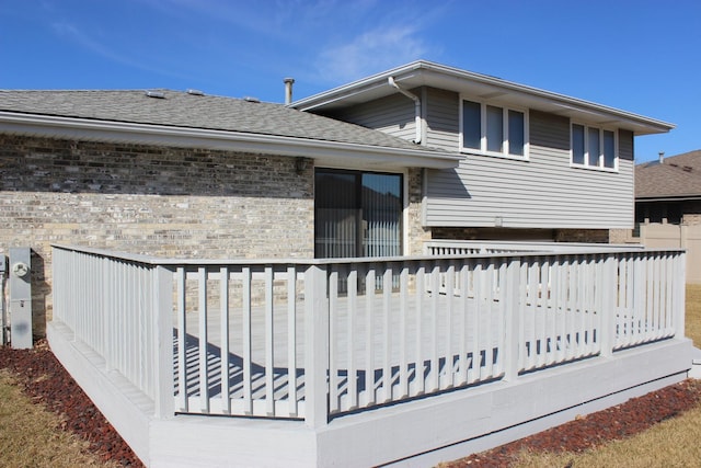 exterior space with brick siding and a shingled roof