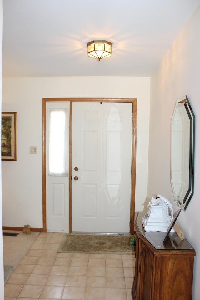 foyer with light tile patterned floors, visible vents, and baseboards