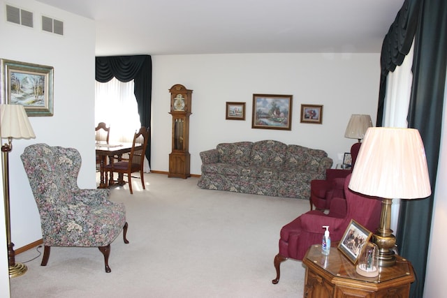 living area featuring carpet flooring, baseboards, and visible vents