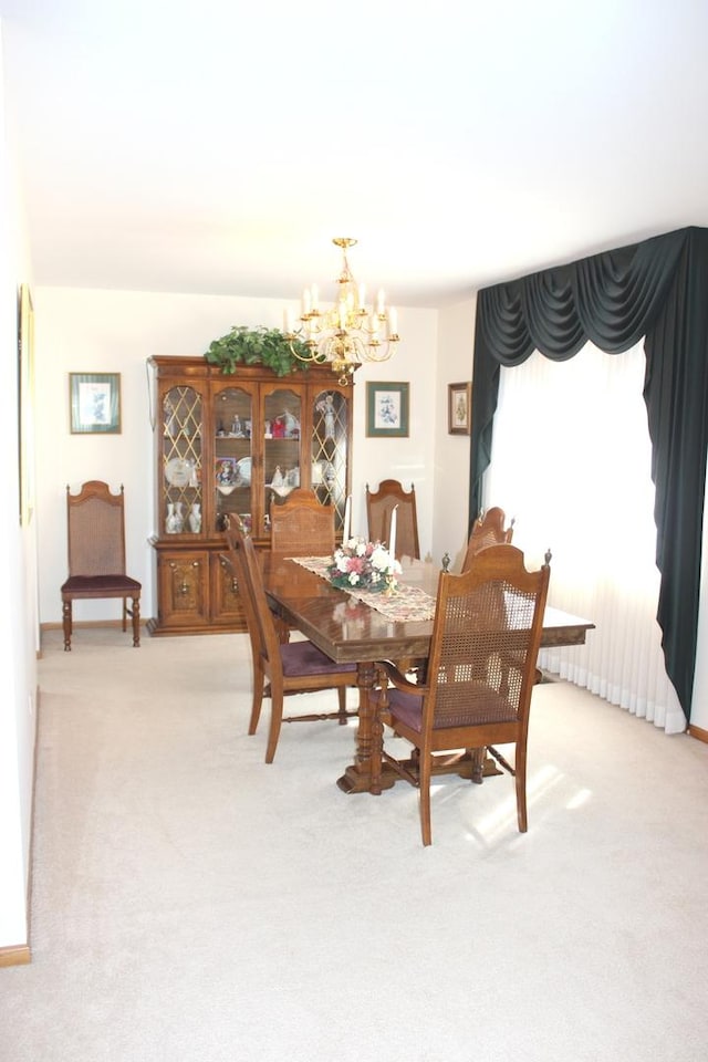 dining room with light carpet and an inviting chandelier