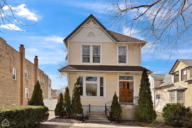 view of front of property with a shingled roof and fence