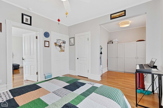 bedroom featuring baseboards, light wood-style flooring, and ornamental molding