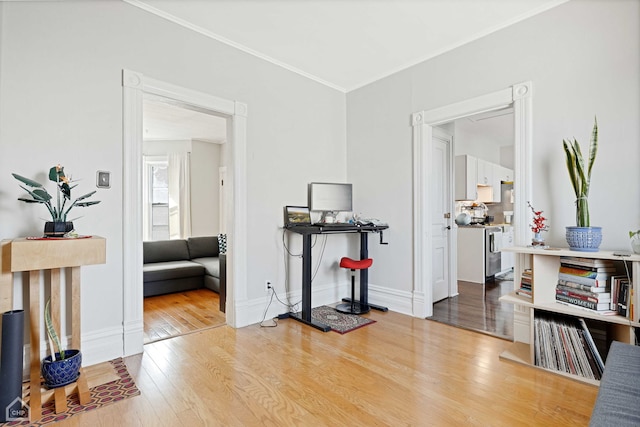 interior space featuring ornamental molding, baseboards, and wood-type flooring