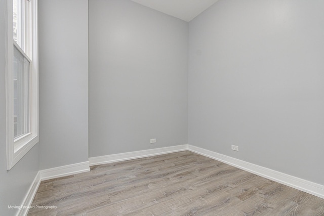 spare room featuring baseboards and light wood-type flooring