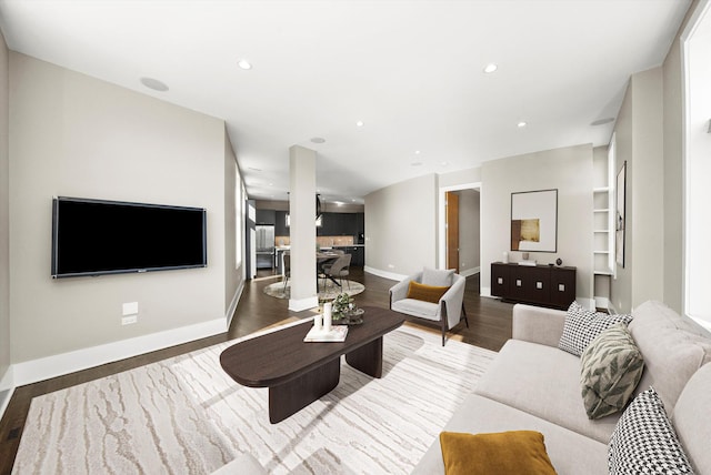 living room with recessed lighting, baseboards, and wood finished floors