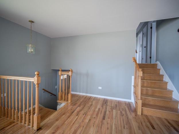 stairs with wood finished floors and baseboards