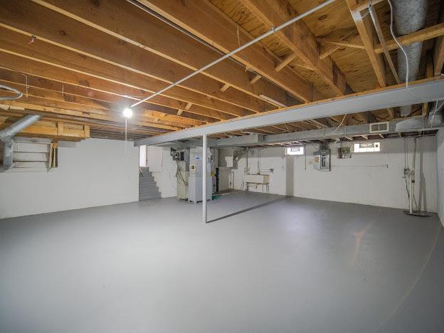 basement featuring electric panel, visible vents, and a sink