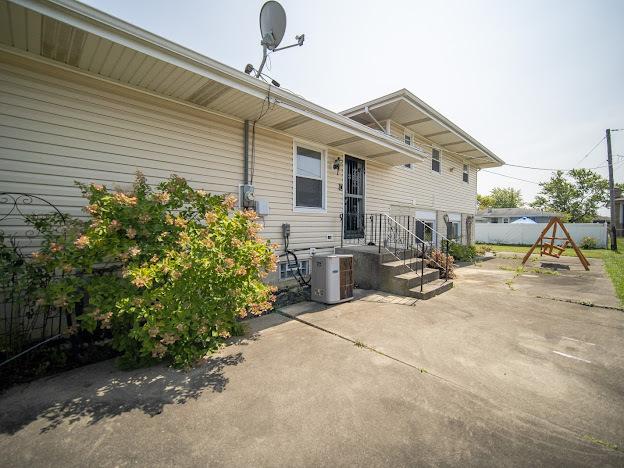 back of property featuring central AC unit, a patio, and fence