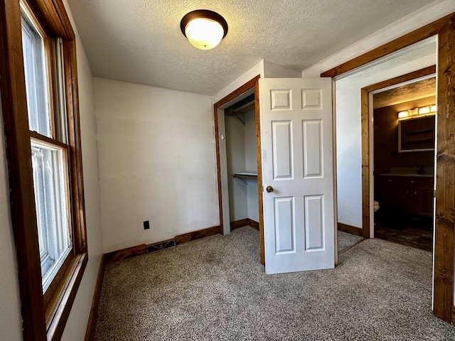 unfurnished bedroom featuring visible vents, baseboards, carpet, a closet, and a textured ceiling