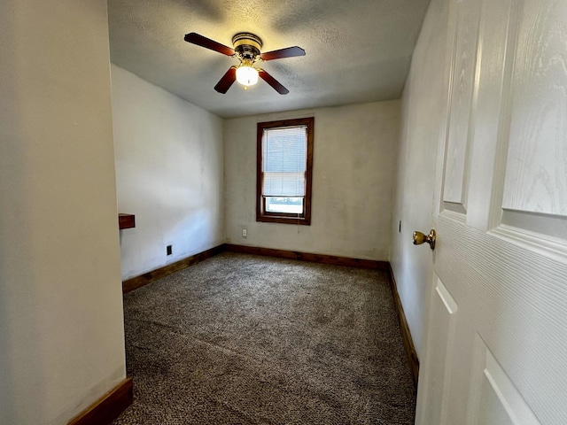 carpeted spare room featuring baseboards, a textured ceiling, and a ceiling fan