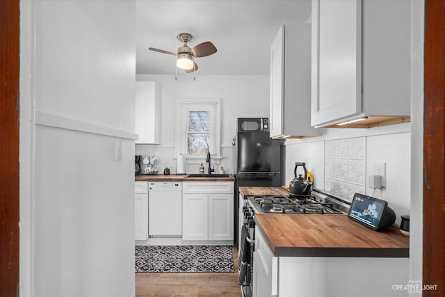 kitchen with backsplash, butcher block counters, dishwasher, stainless steel gas stove, and a sink