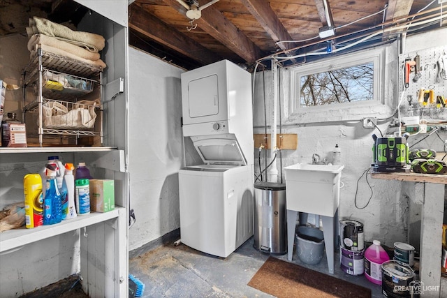 laundry room with a sink, laundry area, and stacked washer / dryer