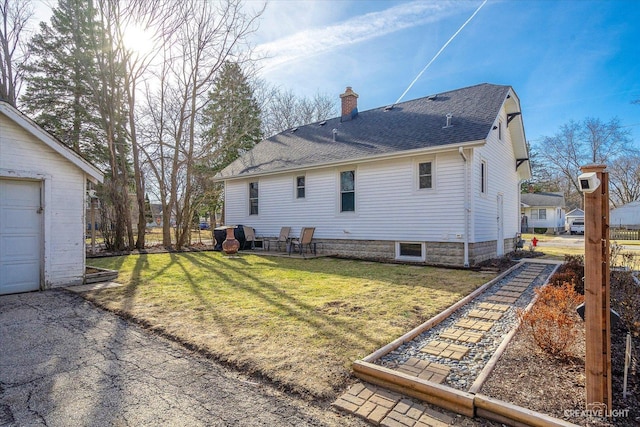 back of property with a lawn, roof with shingles, and a chimney