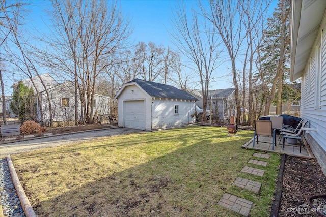 view of yard with a garage, a patio, and an outdoor structure