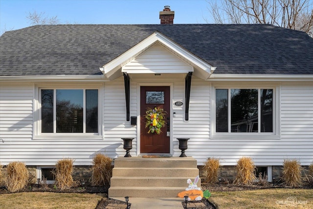 view of front of home with a chimney and a shingled roof