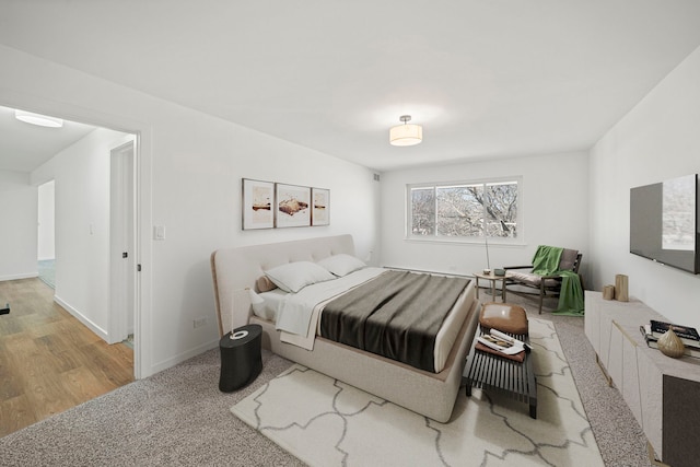 bedroom featuring carpet flooring, wood finished floors, and baseboards