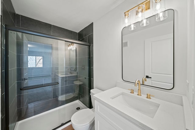 bathroom featuring vanity, a shower stall, toilet, and visible vents