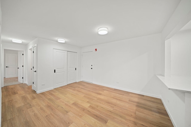 empty room featuring baseboards and light wood-style flooring