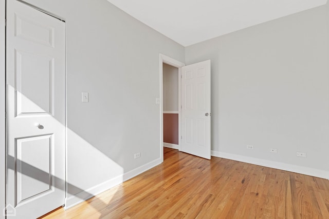 unfurnished room with light wood finished floors and baseboards