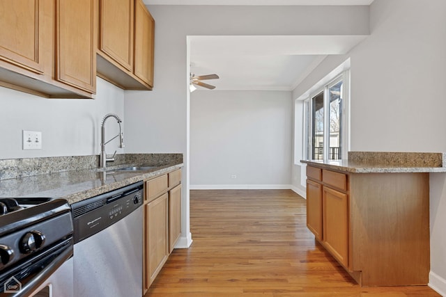 kitchen with light wood-style flooring, a ceiling fan, a sink, stainless steel appliances, and baseboards