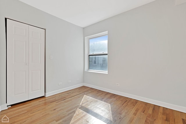 unfurnished bedroom with baseboards and light wood-type flooring