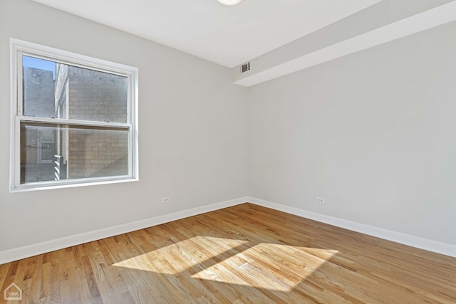 unfurnished room with visible vents, baseboards, and wood finished floors