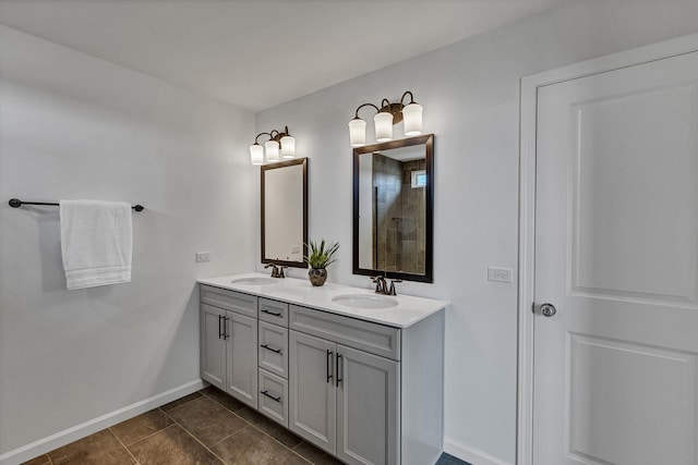 bathroom featuring tile patterned flooring, double vanity, baseboards, and a sink