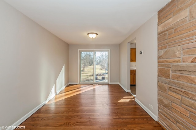 interior space featuring dark wood-type flooring and baseboards