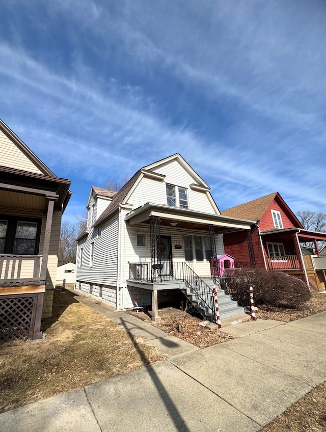 view of front facade featuring roof with shingles and covered porch