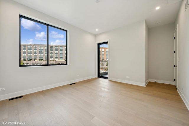 empty room featuring recessed lighting, visible vents, light wood-style flooring, and baseboards