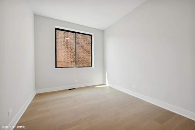 empty room with baseboards and light wood finished floors