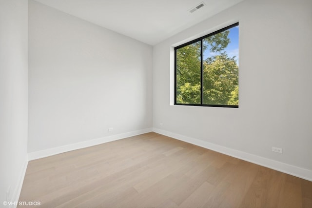 unfurnished room featuring visible vents, baseboards, and wood finished floors