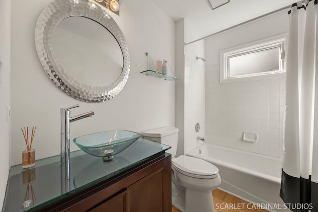 bathroom with shower / bath combination with curtain, wood finished floors, vanity, and toilet