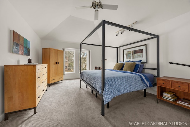 bedroom with light colored carpet, ceiling fan, rail lighting, and lofted ceiling