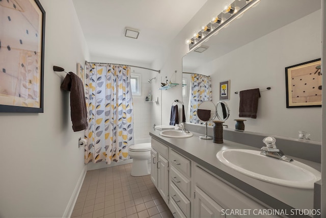 bathroom with a sink, toilet, double vanity, and tile patterned flooring
