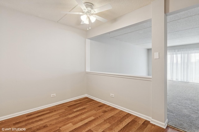 spare room featuring a ceiling fan, baseboards, and wood finished floors