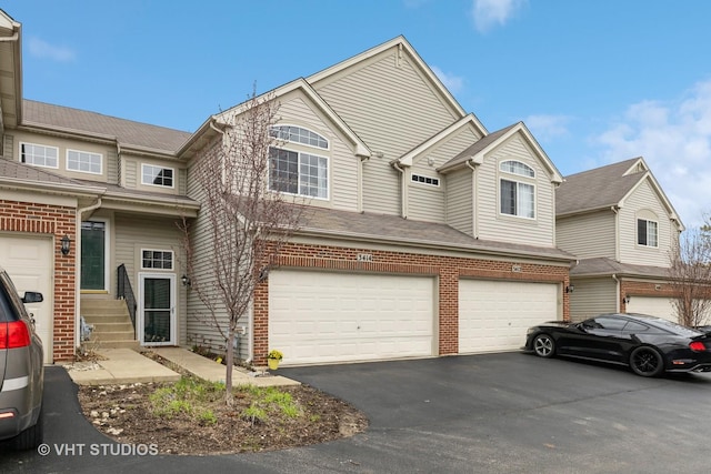 3414 Blue Ridge Dr Unit 3414, Carpentersville, IL 60110 - view of front facade with entry steps, driveway, brick siding, and a garage