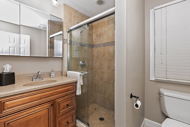 full bathroom featuring a shower stall, toilet, and vanity