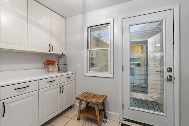 interior space with light tile patterned flooring and baseboards