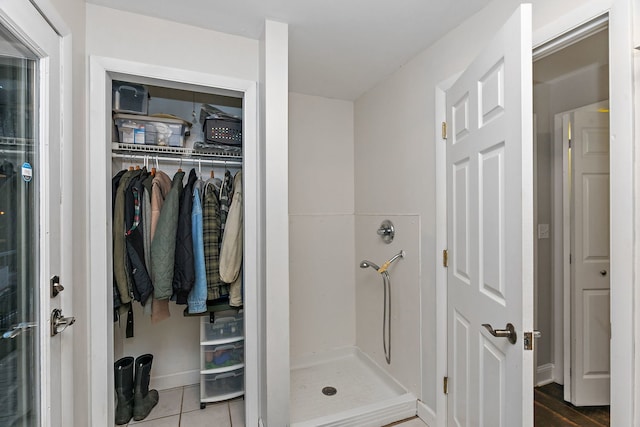 bathroom featuring a shower stall and tile patterned flooring