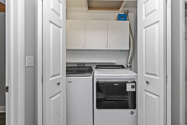 clothes washing area featuring washing machine and dryer and cabinet space