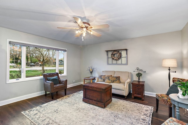 living area with a ceiling fan, baseboards, and wood finished floors