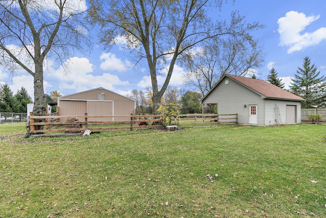 view of yard featuring an outbuilding, fence, and a garage