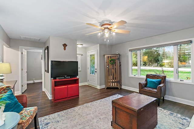 living area with visible vents, baseboards, and wood finished floors