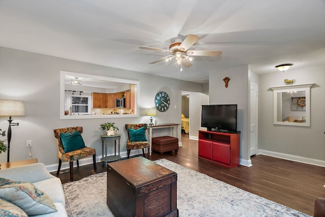 living room featuring wood finished floors, baseboards, and ceiling fan