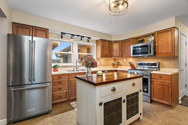 kitchen featuring decorative backsplash, brown cabinets, appliances with stainless steel finishes, and a sink