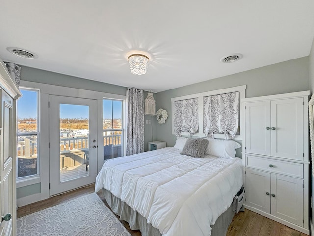 bedroom with access to outside, wood finished floors, visible vents, and french doors