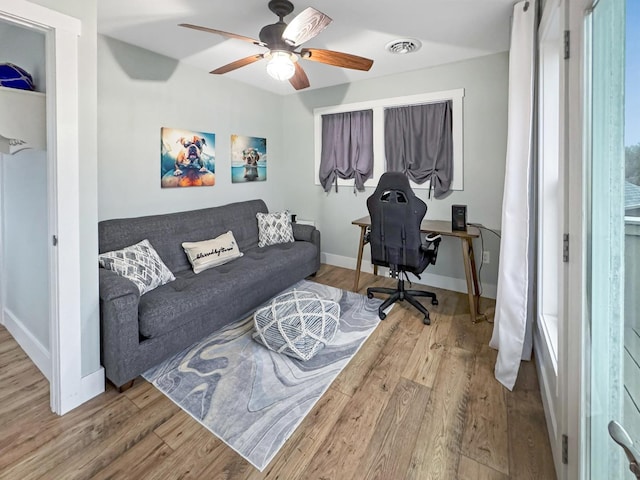 office area featuring ceiling fan, visible vents, baseboards, and wood finished floors