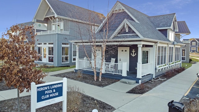 view of front of property featuring a porch, board and batten siding, and roof with shingles