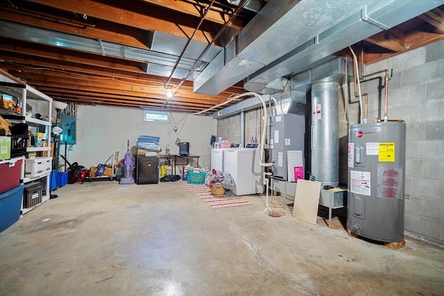 basement featuring heating unit, water heater, and washing machine and clothes dryer